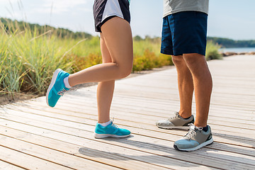 Image showing legs of couple of sportsmen in sneakers outdoors