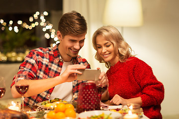 Image showing couple with smartphone at home christmas dinner