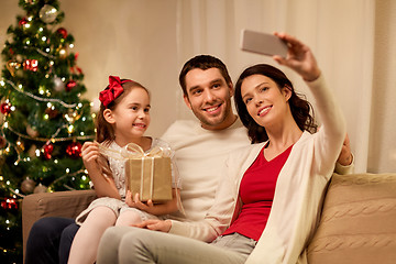 Image showing happy family with christmas present at home