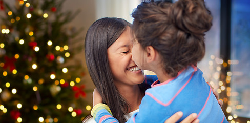 Image showing happy daughter kissing her mother on christmas