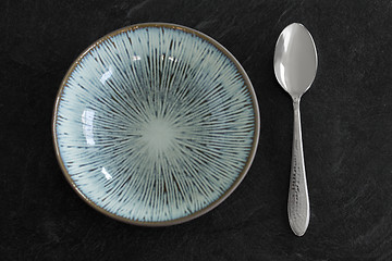 Image showing close up of ceramic plate and spoon on table