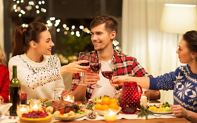 Image showing happy friends drinking red wine at christmas party