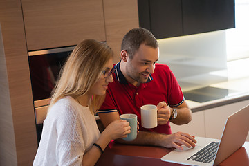 Image showing couple drinking coffee and using laptop at home