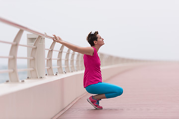 Image showing woman stretching and warming up on the promenade