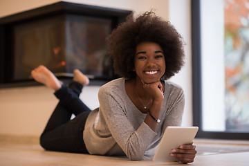 Image showing black women using tablet computer on the floor