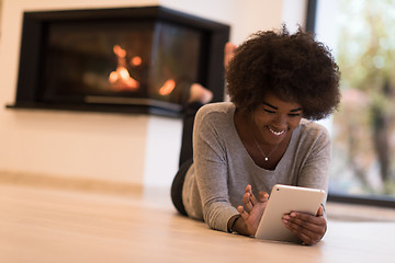 Image showing black women using tablet computer on the floor