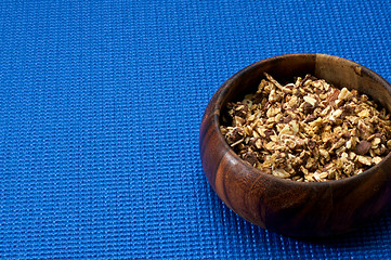 Image showing wooden bowl with granola blue background