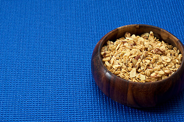 Image showing wooden bowl with granola blue background