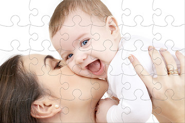 Image showing laughing baby playing with mother puzzle