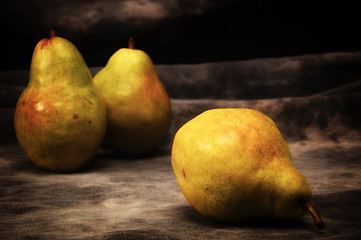 Image showing three golden brown bosc pears on gray studio backdrop