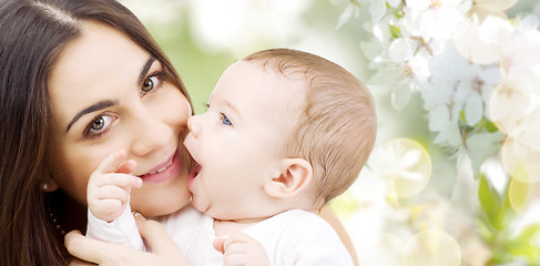 Image showing close up of mother with baby over cherry blossoms