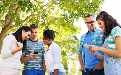 Image showing happy friends with smartphones at summer park