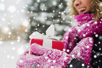 Image showing close up of woman with christmas gift outdoors