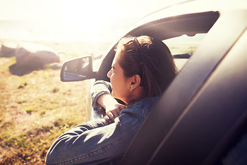 Image showing happy teenage girl or young woman in car