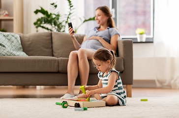 Image showing happy baby girl playing with toy blocks at home