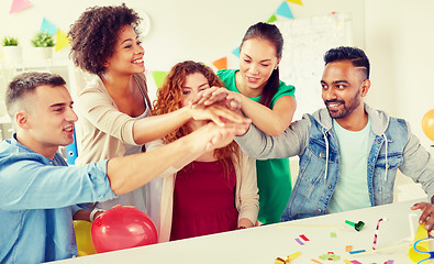 Image showing happy business team at office party holding hands