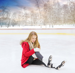 Image showing young woman fell down on outdoor skating rink