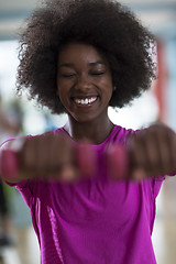 Image showing woman working out in a crossfit gym with dumbbells