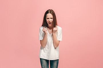Image showing Portrait of angry teen girl on a pink studio background