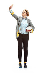 Image showing Full length portrait of a happy smiling female student holding books isolated on white background