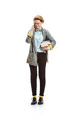 Image showing Full length portrait of a unhappy female student holding books isolated on white background