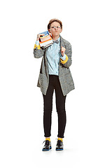 Image showing Full length portrait of a angry female student holding books isolated on white background