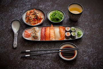 Image showing Asian food assortment. Various sushi rolls placed on ceramic plates