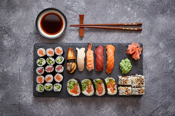 Image showing Composition of different kinds of sushi rolls placed on black stone board