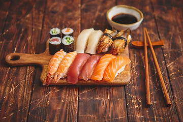 Image showing Sushi Set. Different kinds of sushi rolls on wooden serving board