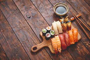 Image showing Sushi Set. Different kinds of sushi rolls on wooden serving board