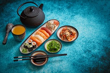 Image showing Asian food assortment. Various sushi rolls placed on ceramic plates