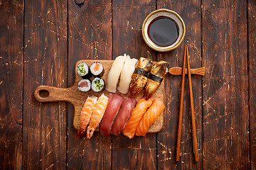 Image showing Sushi Set. Different kinds of sushi rolls on wooden serving board