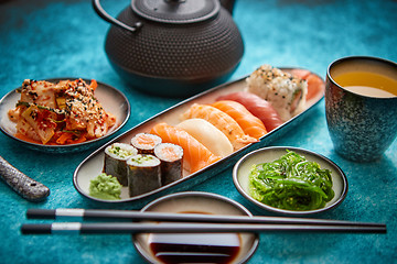 Image showing Asian food assortment. Various sushi rolls placed on ceramic plates