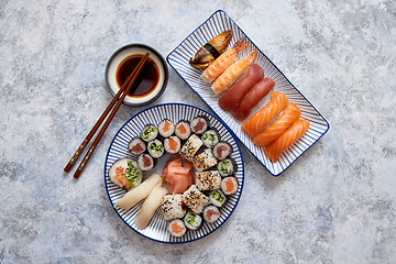 Image showing Asian food assortment. Various sushi rolls placed on ceramic plates