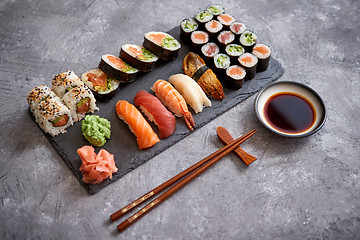 Image showing Composition of different kinds of sushi rolls placed on black stone board