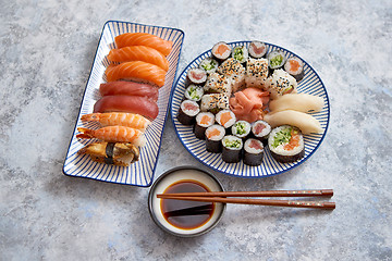 Image showing Asian food assortment. Various sushi rolls placed on ceramic plates