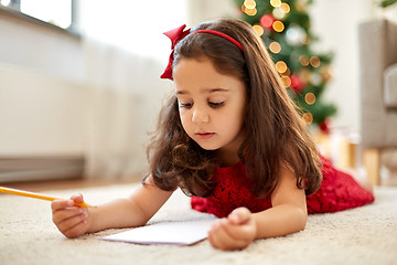 Image showing little girl writing christmas wish list at home