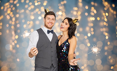 Image showing happy couple with crowns and sparklers at party