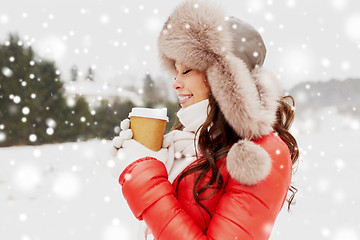 Image showing happy woman in winter fur hat with coffee outdoors