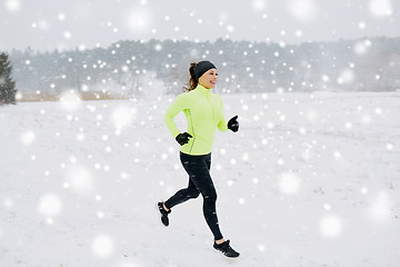 Image showing happy woman running along snow covered winter road