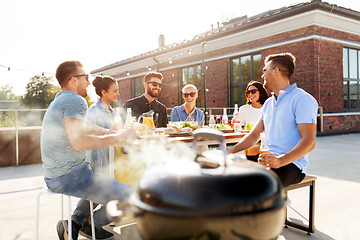 Image showing happy friends at barbecue party on rooftop