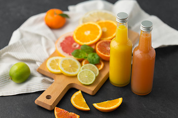 Image showing glass bottles of fruit juice on slate table top