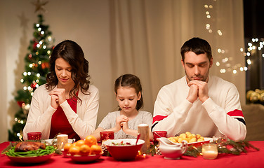 Image showing family praying before meal at christmas dinner