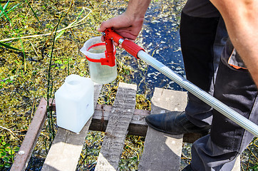 Image showing Take samples of water for laboratory testing. The concept - analysis of water purity, environment, ecology.