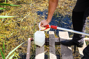 Image showing Take samples of water for laboratory testing. The concept - analysis of water purity, environment, ecology.