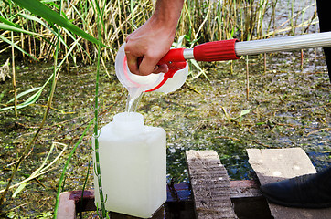 Image showing Take samples of water for laboratory testing. The concept - analysis of water purity, environment, ecology.