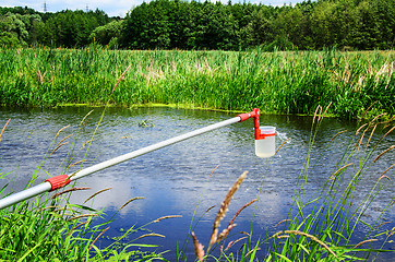 Image showing Take samples of water for laboratory testing. The concept - analysis of water purity, environment, ecology.