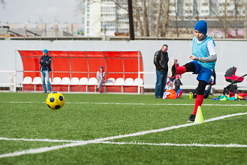 Image showing Boy kicking soccer ball