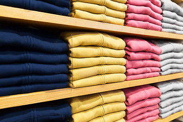 Image showing close up of shelves with clothes at clothing store