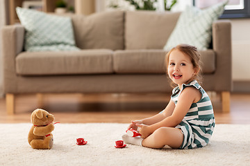 Image showing little girl playing with toy tea set at home